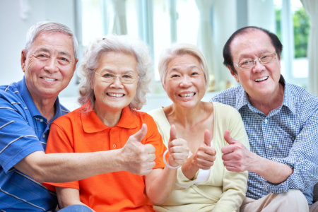 group of Senior chinese friends relaxing on sofa at home